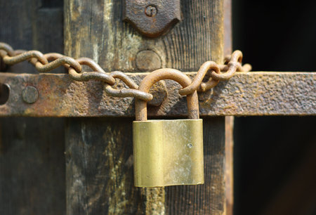Old rusty metal padlock with rusty chain