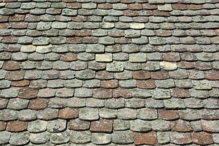 Old tiled roof covered with mossの写真素材