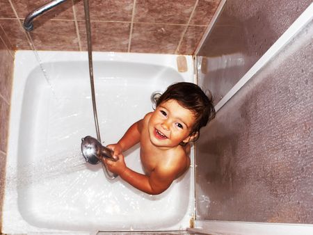 On the image the child. He washes in a per capita cabin independently. In hands holds a shower.の写真素材