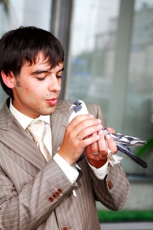 The man costs in a jacket. At it in hands a pigeonの写真素材