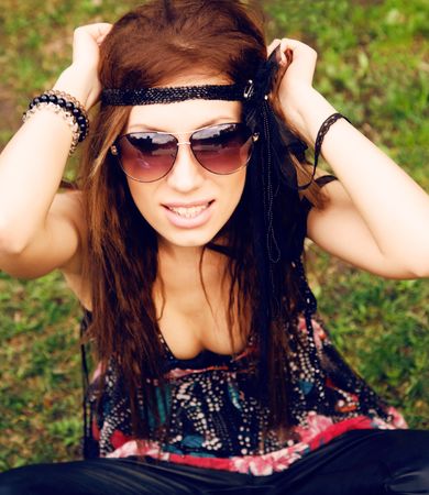 Beautiful young hippie girl sitting in the grassの写真素材
