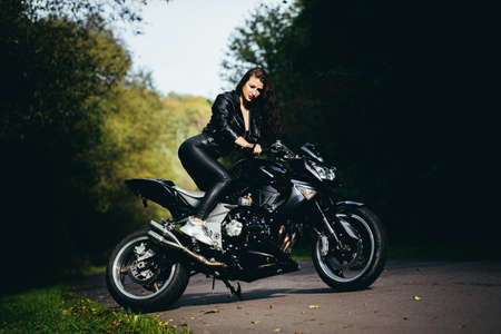 Biker sexy woman sitting on motorcycle. Outdoor lifestyle portraitの写真素材