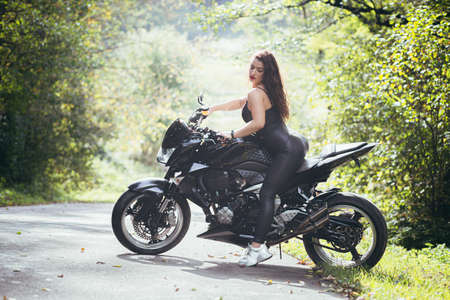 Biker sexy woman sitting on motorcycle. Outdoor lifestyle portraitの写真素材