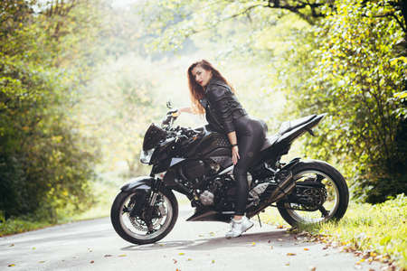 Biker sexy woman sitting on motorcycle. Outdoor lifestyle portraitの写真素材