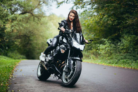 Biker sexy woman sitting on motorcycle. Outdoor lifestyle portraitの写真素材