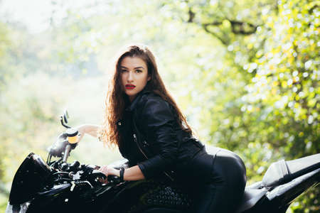 Biker sexy woman sitting on motorcycle. Outdoor lifestyle portraitの写真素材