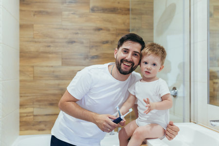 man father teaches his son the boy in the bathroom brushing teeth, happyの写真素材
