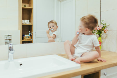 Little kid boy brushing teeth in his bathroom, baby taking care of teethの写真素材
