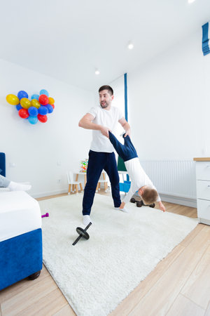 Young man father, doing morning exercise with his two young sons. Spend time together in the nurseryの写真素材