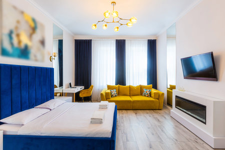 Interior photography, large bedroom in a modern loft style, with a double bed and a yellow sofa