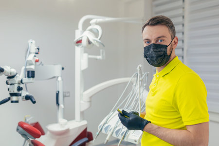 Close up portrait of a confident dentist in a medical office or clinic. Attractive bearded young...
