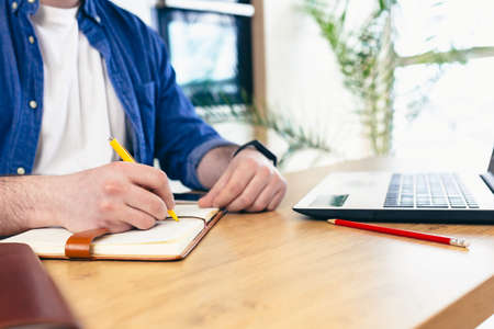 Businesswoman sitting at office desk and typing on a laptop hands close upの写真素材
