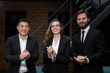 International team of businessmen in formal suits folds their arms and smiles after a successful...