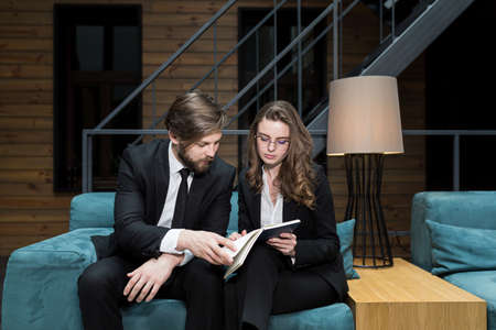 Two colleagues, a man and a woman, discuss business, sitting in a restaurant, satisfaction with the decision and successの写真素材