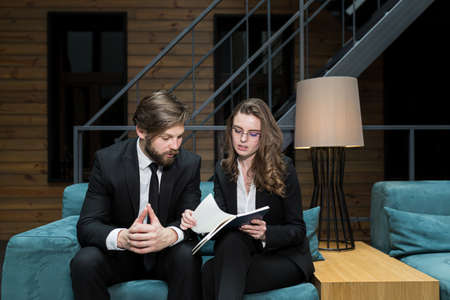 Two colleagues, a man and a woman, discuss business, sitting in a restaurant, satisfaction with the decision and successの写真素材