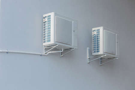 Two large fans are mounted on a white wall, air conditioning fansの写真素材