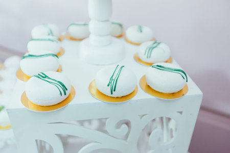 Candy bar. White festive table with deserts, strawberry tartlet and cupcakes. Wedding. Reception...