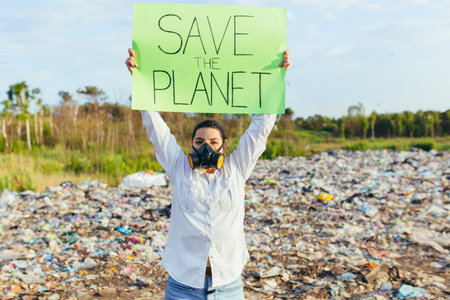 Woman with a poster save the planet, pickets garbage-contaminated environment, burning fire and...