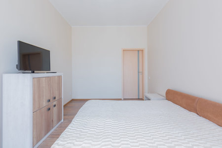 interior of a bedroom with a large bed in light colors
