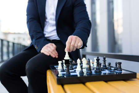 Close-up photo of businessman's hands making a move on a chessboard, male businessman playing chessの写真素材