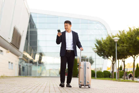 Businessman corresponded in a mobile phone uses the messenger application to communicate with colleagues at a distanceの写真素材