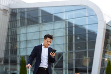 Businessman corresponded in a mobile phone uses the messenger application to communicate with colleagues at a distanceの写真素材