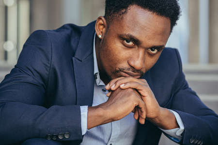 Depressed african american businessman looking at camera close up portraitの写真素材