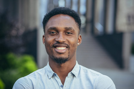 Portrait of a young cheerful African American man looking at the camera, smiling and rejoicingの写真素材