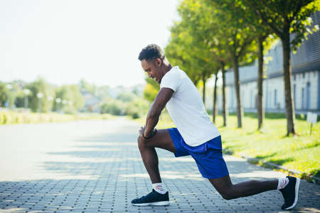 Athletic African American man doing morning workouts, stretching and fitnessの写真素材