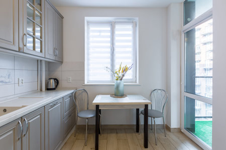 Interior of a modern beige and gray kitchen in a small smart apartment