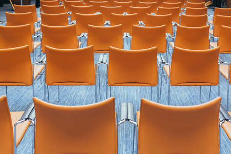 large empty conference room with orange chairs before the auctionの写真素材