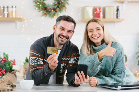 Young happy family during the New Year and Christmas holidays at home joyful buy gifts online using...