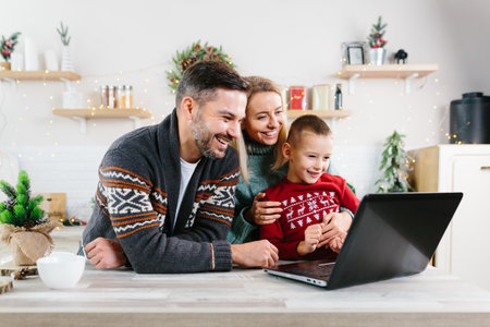 Family man woman and little son having fun shopping online using laptop, choosing gifts for Christmas and New Yearの写真素材