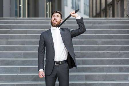 Frustrated and depressed man takes off his tie, businessman fired from officeの写真素材