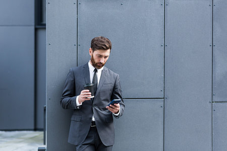 Caucasian bearded employee on urban background office building texting Messages, read good news...