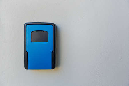 The blue key box of the apartment is placed on the wallの写真素材