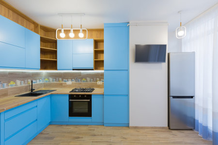 Interior of a large blue kitchen with wood in the apartment