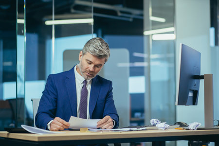 Businessman received a consolation letter, anxious and annoyed working at the computer, man at work