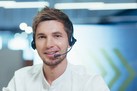 Portrait young handsome man in headphones gives an online lecture, looks at the camera, explains,...