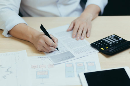 A close-up photo of a businessmans hand working on paperwork, an accountant, a financier, calculates...