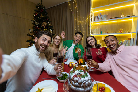 Video call for Christmas, various friends talking on a smartphone and taking a selfie joint photo sitting at home at the festive table near the Christmas tree, New Year holidays.の写真素材