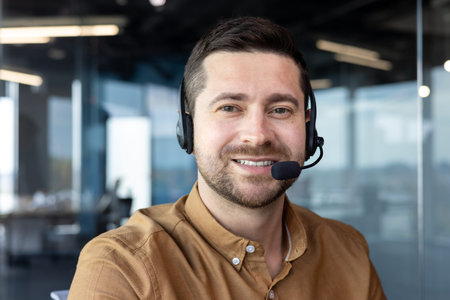 Portrait of the face of a young businessman working in the office wearing a headset. Smiling and...