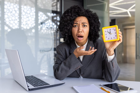 Overworked woman working late, businesswoman looking at camera upset showing clock, female worker...