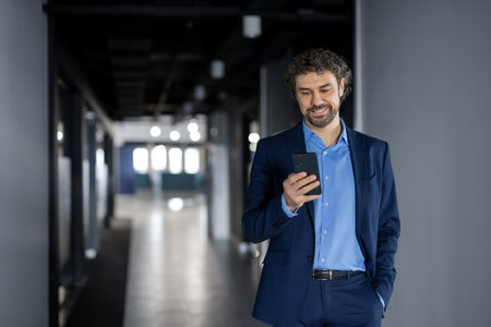 Mature experienced successful businessman in business suit walking inside office building, man...