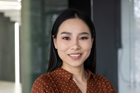 Confident female professional standing in a corporate office setting, exuding a sense of ambition and expertise.の写真素材