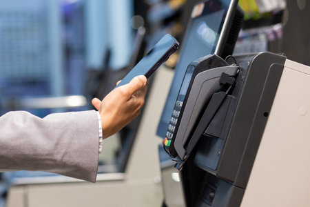 A person uses a smartphone for contactless payment at a store, offering convenience in retail with NFC technology. Its popular for safety and quick transactions, making it a modern and secure way to shop and payの写真素材