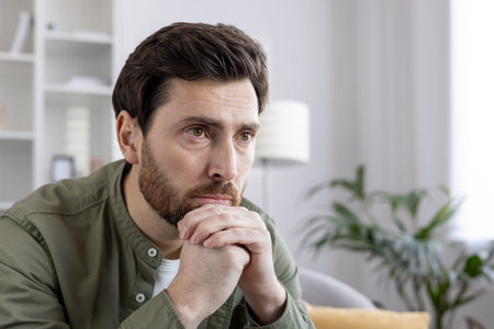 Thoughtful man looking pensive while contemplating life and challenges. Captures emotional depth,...