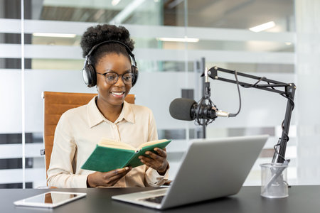 African American businesswoman using laptop and microphone for podcast recording. Concept of...