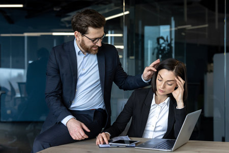 A male boss and a female employee at the workplace inside the office.の写真素材