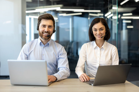 Friendly customer support representatives using laptops engaged in communication with clients....